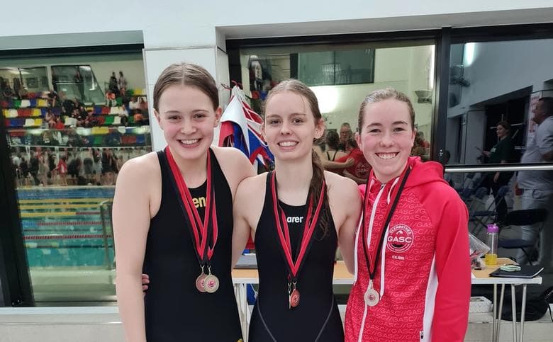 Three winning girls standing side by side